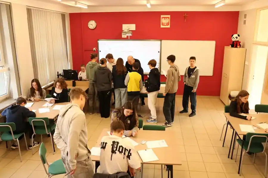 Uczniowie pracujący w grupach na warsztatach